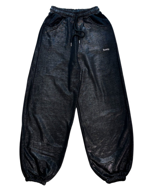 Vista frontale del pantalone Disclaimer nero effetto laminato con vestibilità morbida.